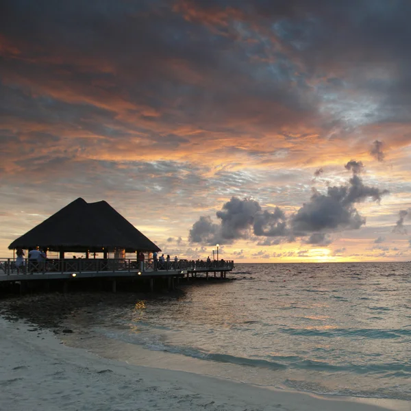 Pláž a tropické domy na sunset — Stock fotografie