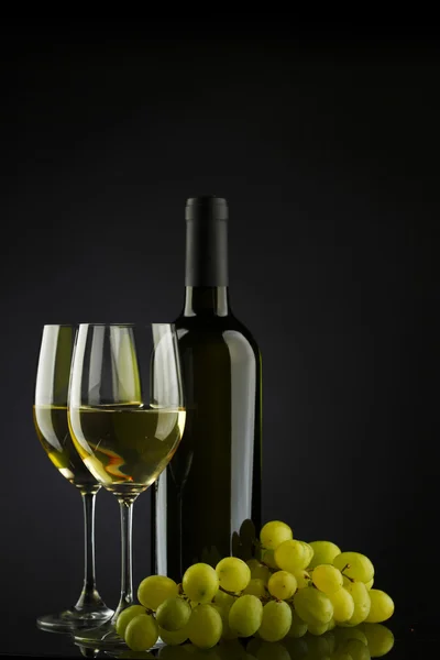 Flaska med vitt vin och glas och druvor — Stockfoto