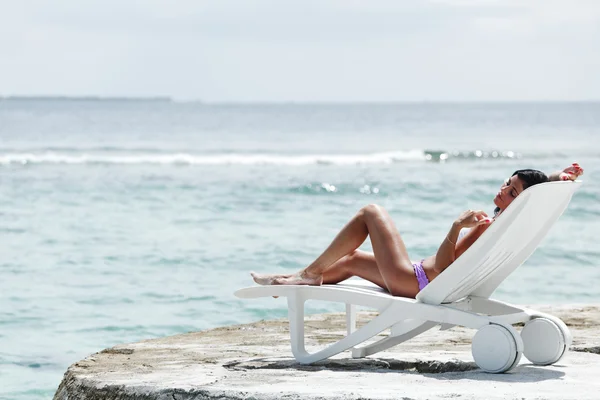 Woman in chaise-lounge near sea — Stock Photo, Image