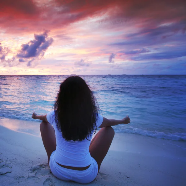 Mulher de ioga na praia ao pôr do sol — Fotografia de Stock