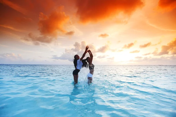 Glückliche Frauen spielen im Wasser — Stockfoto