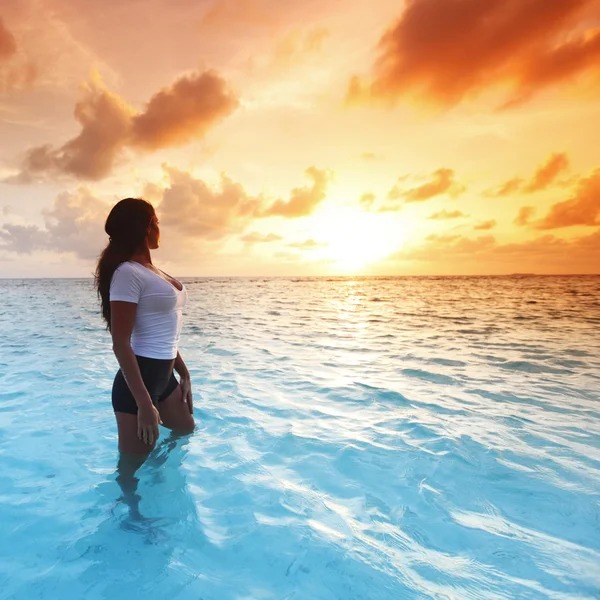 Femme en mer au coucher du soleil — Photo