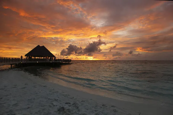 Strand en tropische huizen op zonsondergang — Stockfoto
