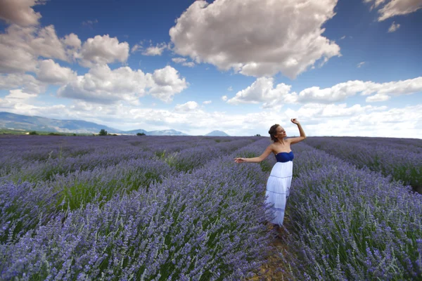 Kvinna stående på ett lavendelfält — Stockfoto