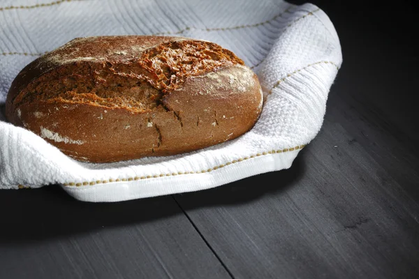Bread and fabric on black table — Stock Photo, Image