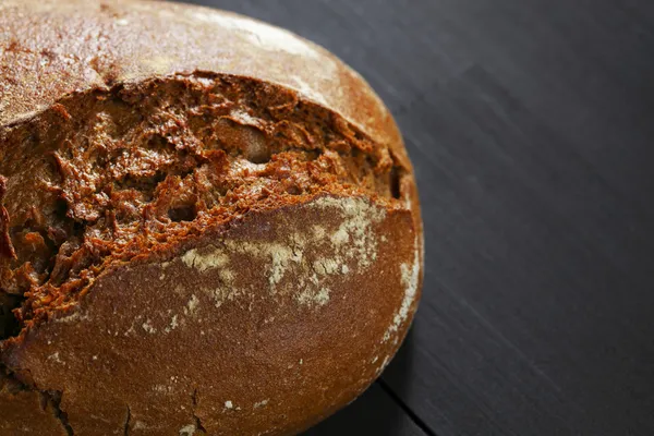 Whole black bread on table — Stock Photo, Image