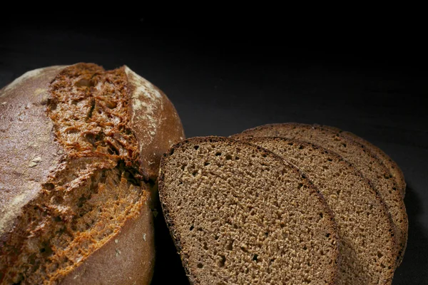 Pão preto fatiado na mesa de madeira — Fotografia de Stock