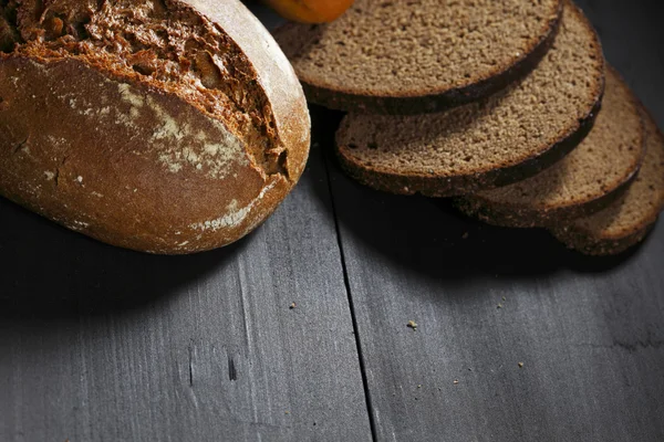 Pane nero affettato sul tavolo di legno — Foto Stock