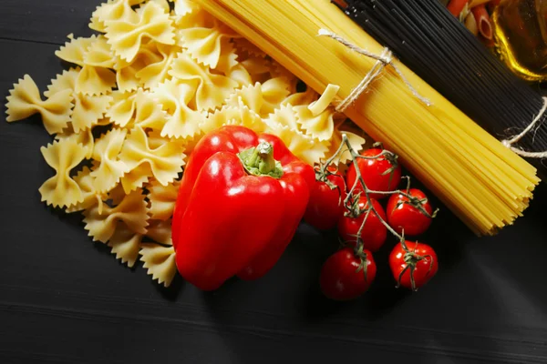 Pasta ingredients on black table — Stock Photo, Image