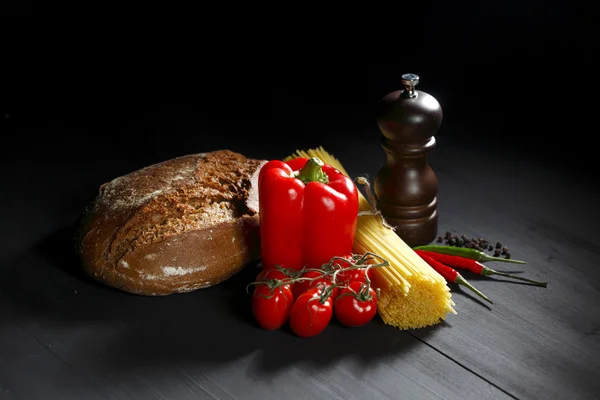 Ingredientes de massas na mesa preta — Fotografia de Stock