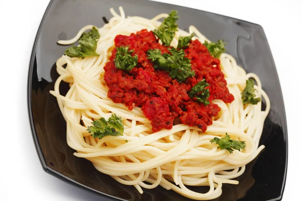 Spaghetti bolognese on black plate — Stock Photo, Image