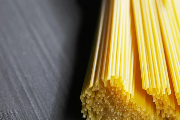 Raw pasta on black table — Stock Photo, Image