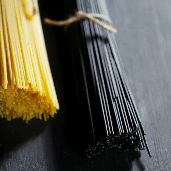 Svart och vit torr spaghetti — Stockfoto