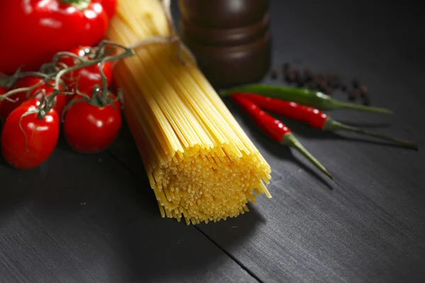 Ingredientes de massas na mesa preta — Fotografia de Stock