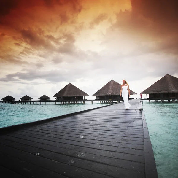 Femme en robe sur le coucher du soleil maldivien — Photo