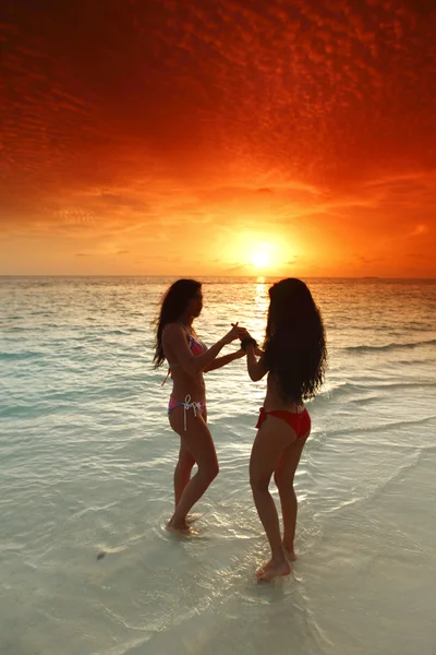 Deux femmes profitant du coucher de soleil sur la plage — Photo