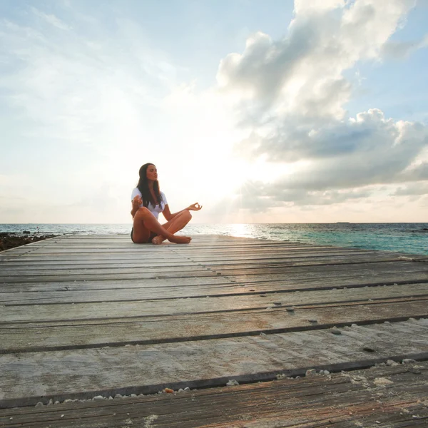 Mujer yoga meditando cerca del mar — Foto de Stock