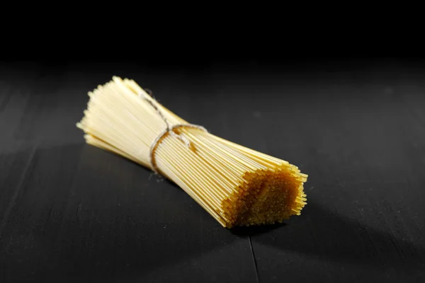 Raw pasta on black table — Stock Photo, Image