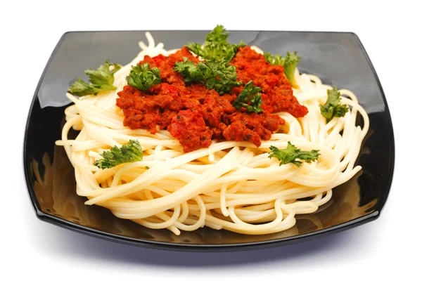 Spaghetti bolognese on black plate — Stock Photo, Image