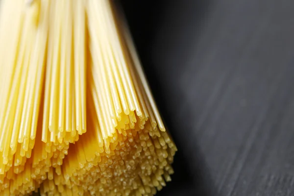 Rå pasta på svart bord — Stockfoto