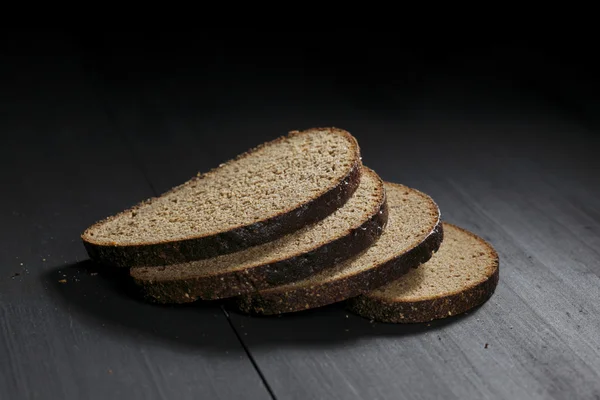 Ahşap masa üzerinde siyah ekmek dilimlenmiş — Stok fotoğraf