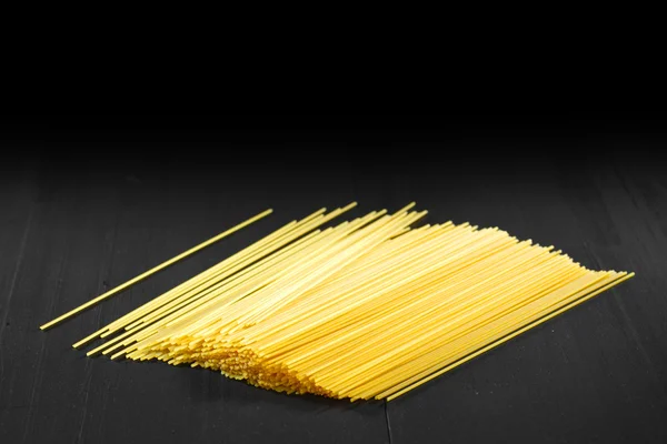 Raw pasta on black table — Stock Photo, Image