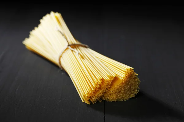 Raw pasta on black table — Stock Photo, Image