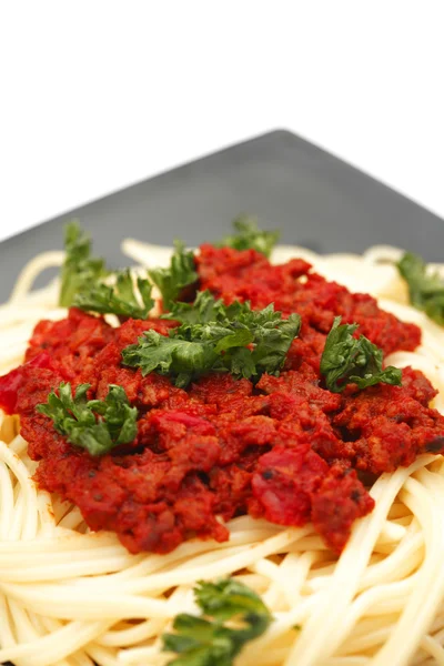 Spaghetti bolognese na czarnej płycie — Zdjęcie stockowe