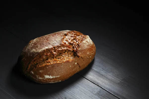 Whole black bread on table — Stock Photo, Image