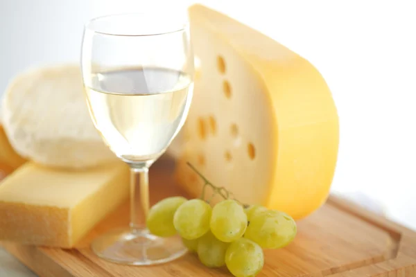 Queijo e vinho em uma mesa de madeira — Fotografia de Stock