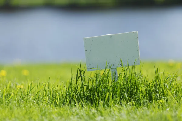 Letrero blanco sobre hierba —  Fotos de Stock