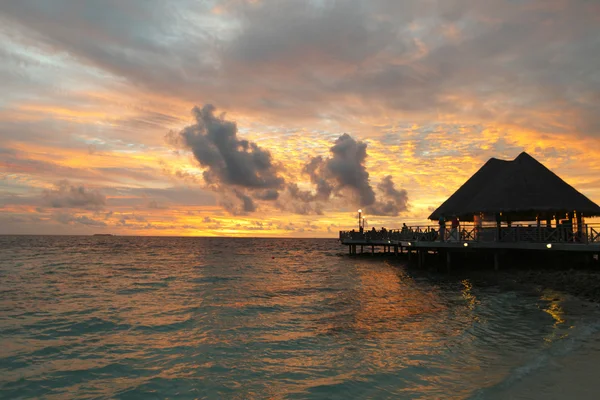 Plage et maisons tropicales au coucher du soleil — Photo