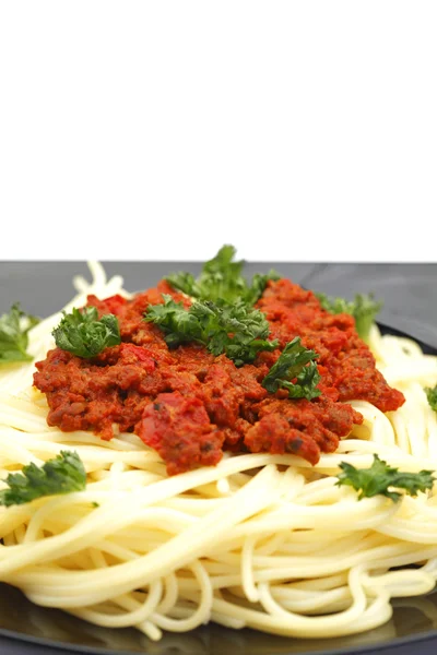 Spaghetti bolognese na czarnej płycie — Zdjęcie stockowe