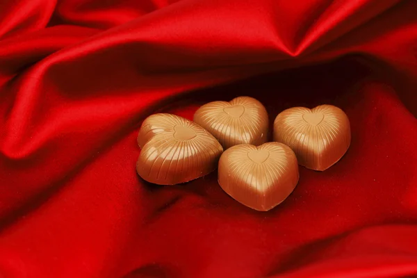 Coeurs de bonbons sur satin rouge — Photo