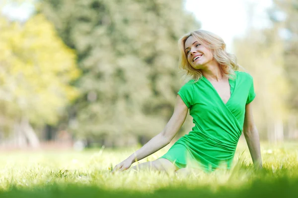 Femme assise sur l'herbe — Photo