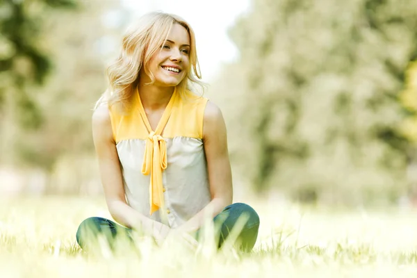 Vrouw zittend op gras — Stockfoto