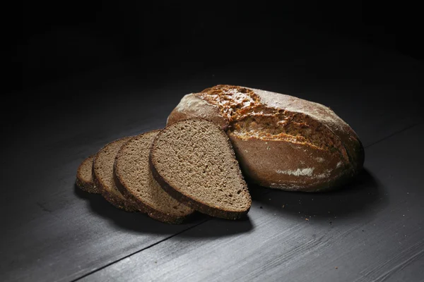 Pane nero affettato sul tavolo di legno — Foto Stock