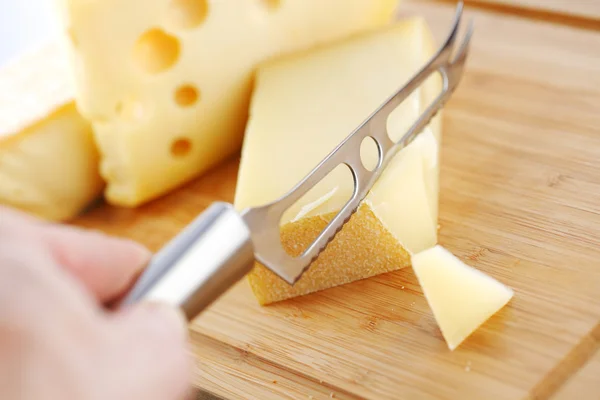 Käse mit einem Käsemesser — Stockfoto