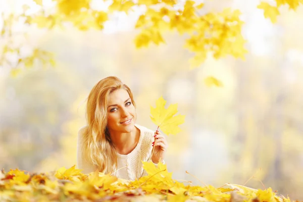 Frau liegt im Herbstpark — Stockfoto