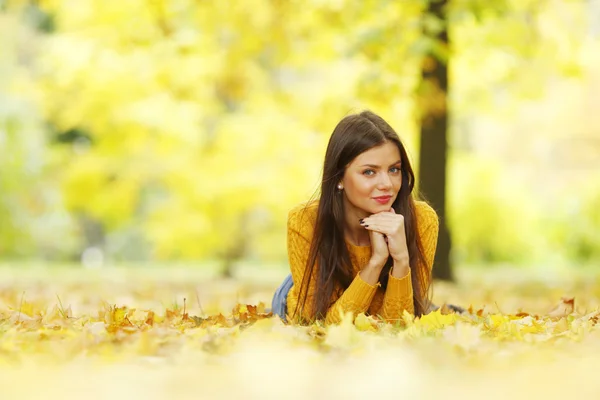 Meisje opleggen herfst bladeren — Stockfoto