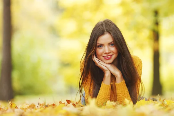 Meisje opleggen herfst bladeren — Stockfoto