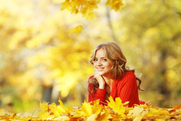 Mujer acostada en hojas de otoño — Foto de Stock