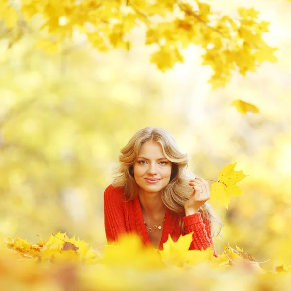 Vrouw opleggen Herfstbladeren — Stockfoto