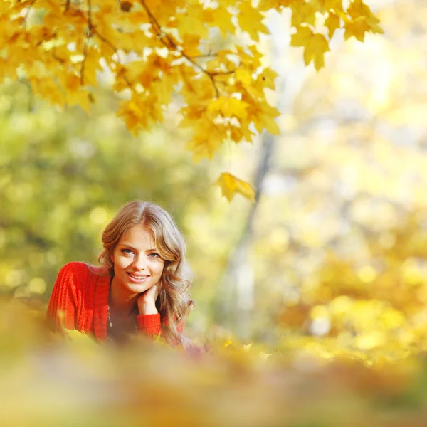 Mujer acostada en hojas de otoño — Foto de Stock