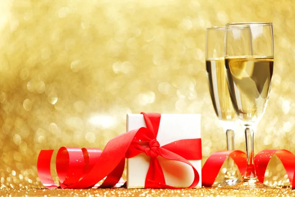 Champagne glasses and gift — Stock Photo, Image