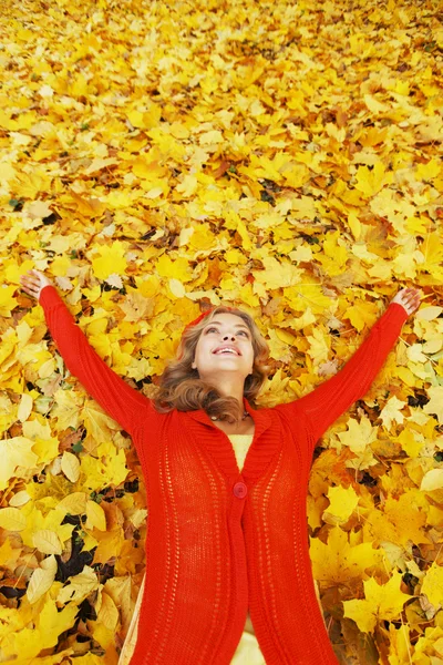 Donna che posa su foglie autunnali — Foto Stock