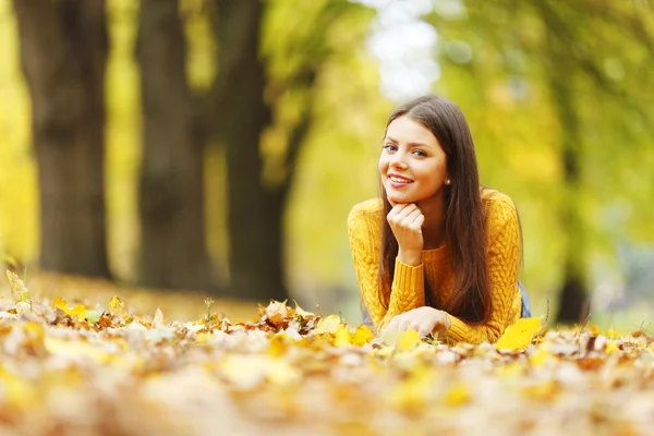 Дівчина лежить на осінніх листках — стокове фото
