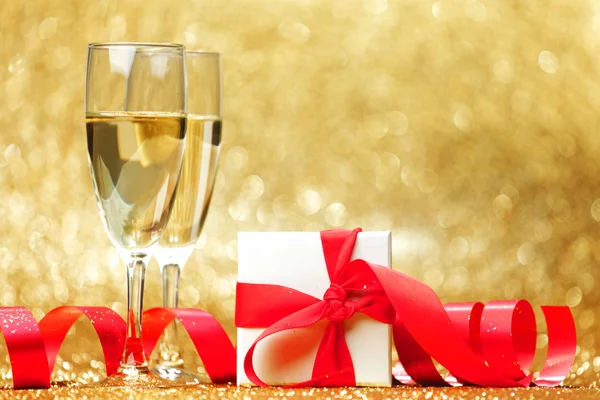 Champagne glasses and gift — Stock Photo, Image