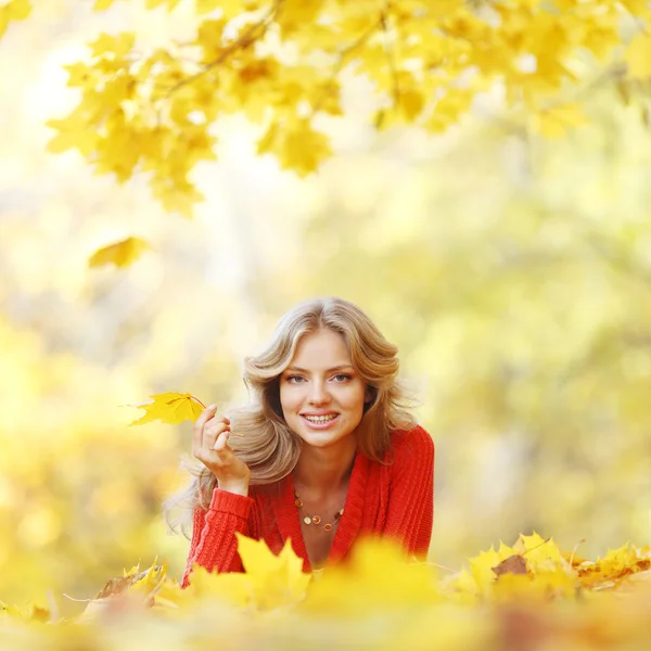 Mujer acostada en hojas de otoño — Foto de Stock