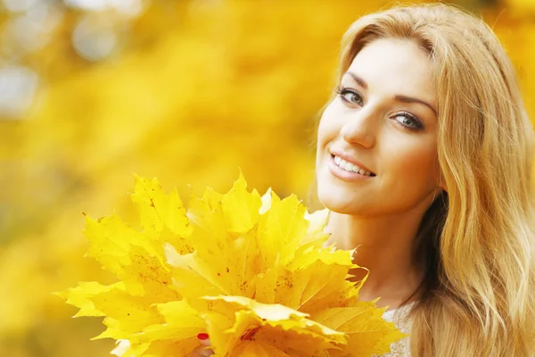 Lächelnde Frau im Herbstpark — Stockfoto
